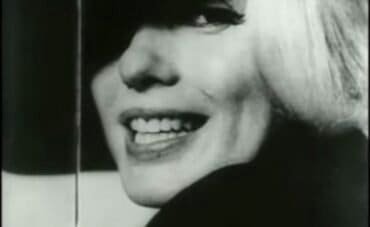 Primo piano in bianco e nero di Marilyn Monroe che sorride con la bocca aperta.