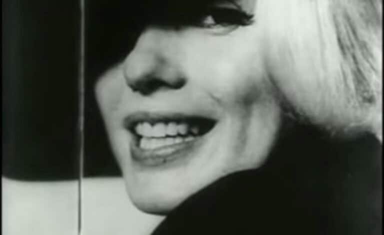 Primo piano in bianco e nero di Marilyn Monroe che sorride con la bocca aperta.