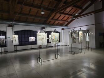 Galleria d'arte interna con quadri appesi e illuminati