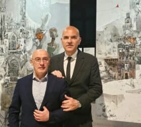 Due uomini in abito davanti a un quadro artistico