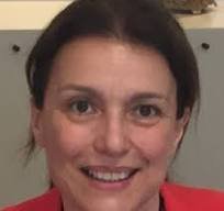 Primo piano di donna sorridente con capelli scuri raccolti