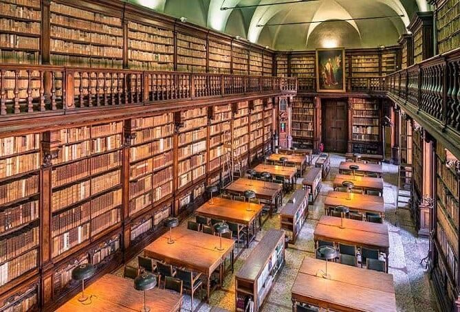 Antica biblioteca con scaffali di libri e tavoli di legno