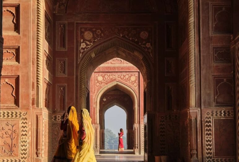 Donne in sari camminano in corridoio architettonico